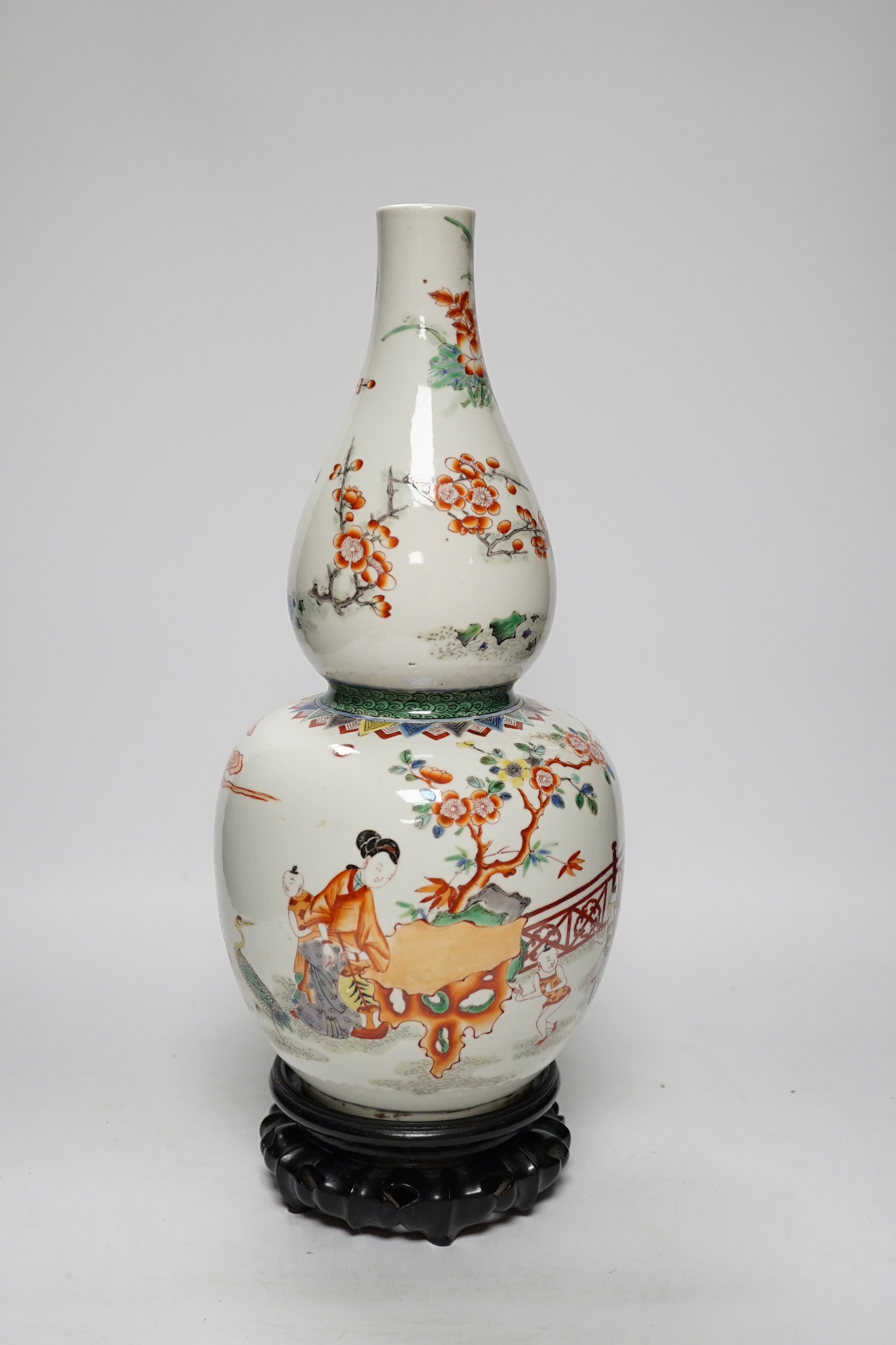 A Chinese enamelled porcelain double-gourd vase on hardwood stand, 41cm total height